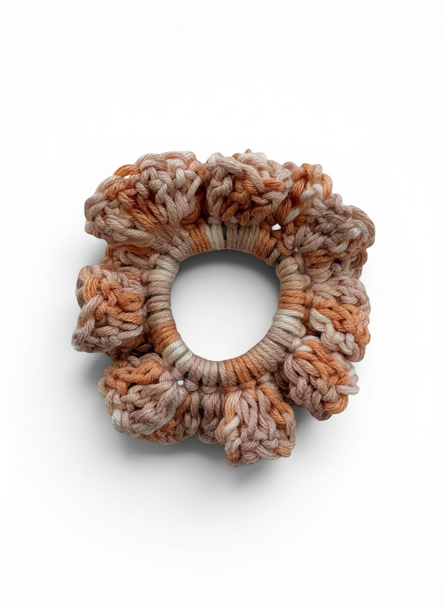 Criminal Crochet handmade crochet scrunchie in earthy tones with a textured, floral-like pattern. Soft yarn hair accessory.