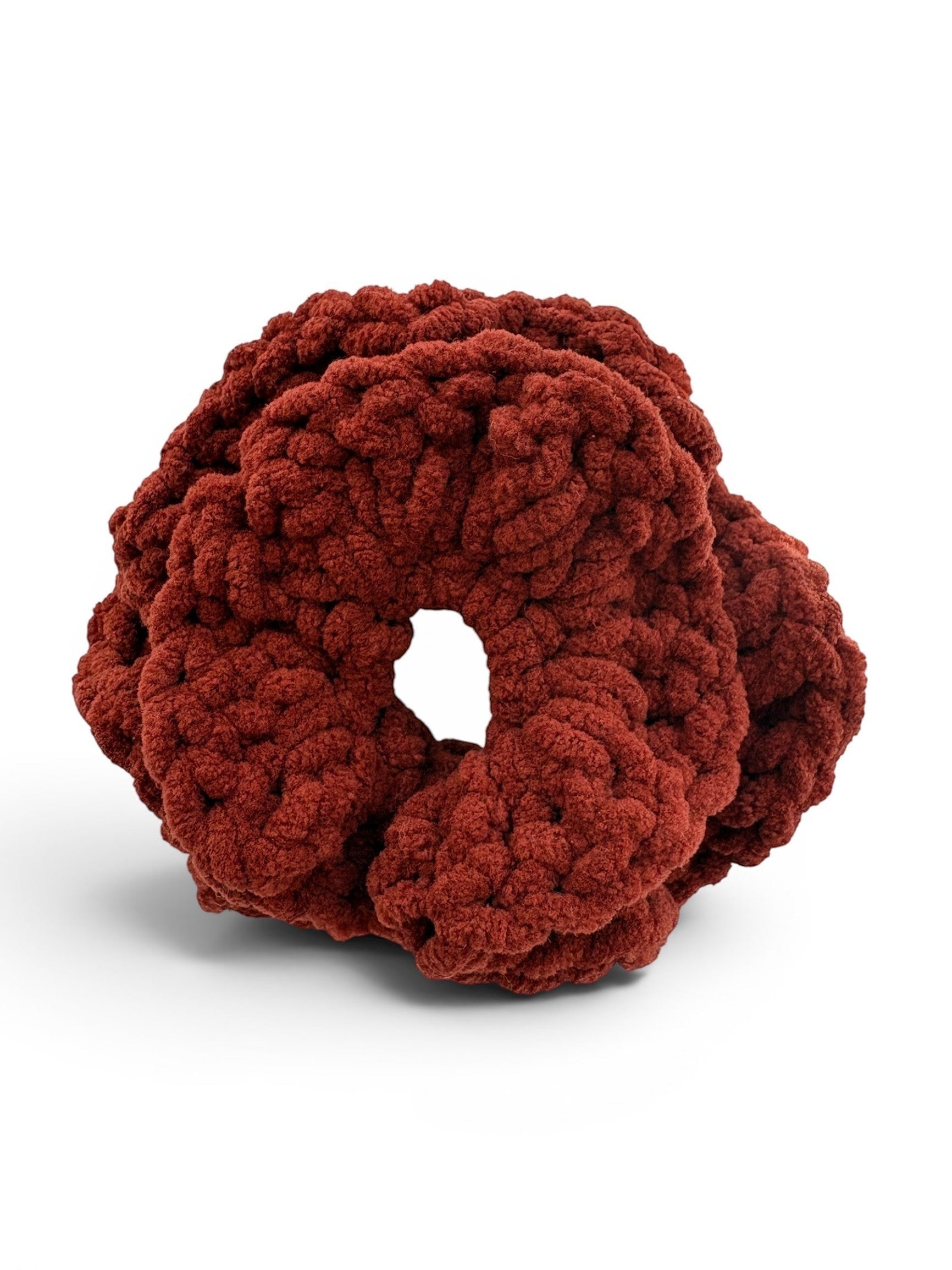 Criminal Crochet rust-colored chunky knit crochet scrunchie hair accessory with a textured pattern.
